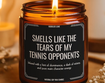 Puede incluir: Una vela encendida en un frasco de vidrio ámbar con una etiqueta negra que dice: RUBULUS LUME, SMELLS LIKE THE TEARS OF MY TENNIS OPPONENTS, Infused with a hint of dominance, a dash of victory, and pure main character energy, NATURAL SOY WAX CANDLE.
