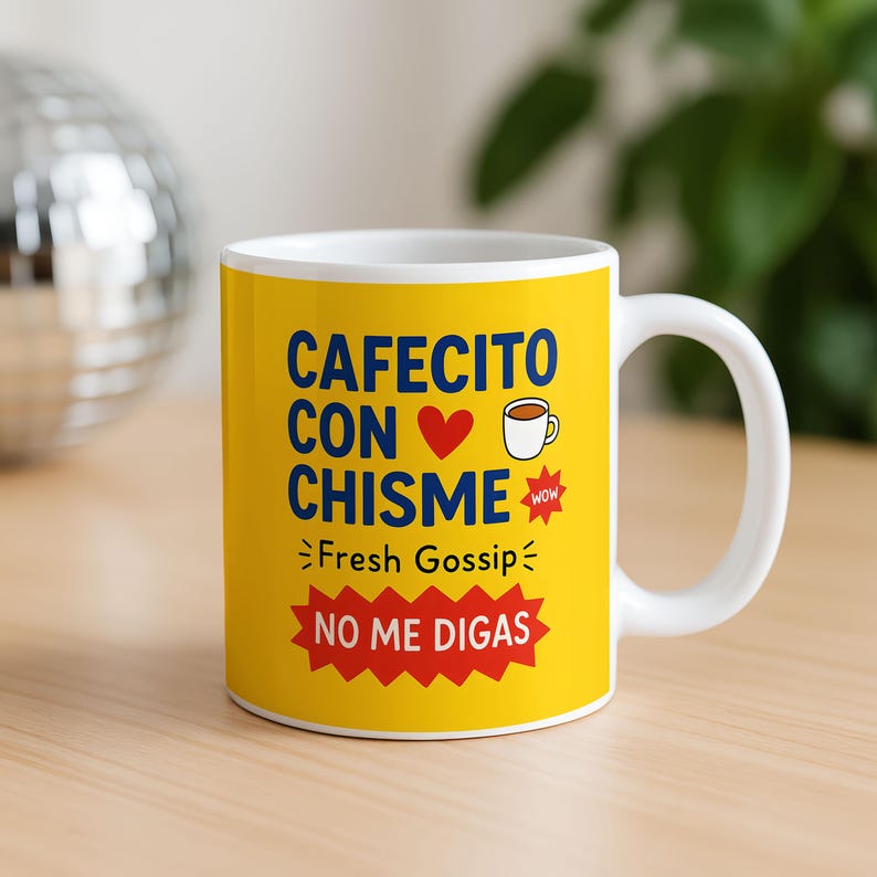May include: A white ceramic coffee mug with a yellow background. The mug features the text "CAFECITO CON CHISME" in blue, with a red heart and a coffee cup graphic. Below, it says "Fresh Gossip" and "NO ME DIGAS" in a red starburst.