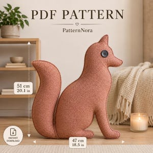 Könnte beinhalten: Ein fuchsformiges Stoffkissen aus strukturiertem terrakottafarbenem Stoff mit einem schwarzen Knopfauge. Der Text lautet PDF PATTERN, PatternNora und INSTANT DOWNLOAD. Die Maße betragen 51 cm Höhe und 47 cm Breite, markiert durch Pfeile.