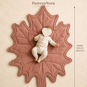 May include: A dusty rose leaf-shaped quilted play mat with stitched vein details. The mat measures 48.8 inches in length and 33.1 inches in width. The text PDF PATTERN and PatternNora are visible at the top of the image.