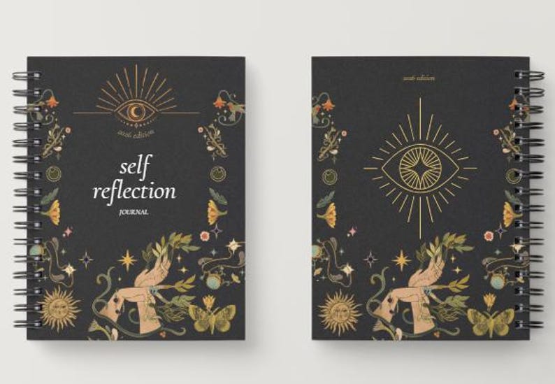 Peut inclure: Deux journaux &agrave; spirales avec des couvertures noires. Le journal de gauche porte les mots "self reflection journal" et un motif d'&oelig;il. Le journal de droite a un motif d'&oelig;il. Les deux journaux ont des illustrations florales et de papillons.