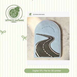 Puede incluir: Un diseño en forma de arco azul claro con un gráfico de carretera y las palabras "Happy Birthday". La carretera es negra con líneas discontinuas blancas. El diseño es un archivo STL digital para una impresora 3D.