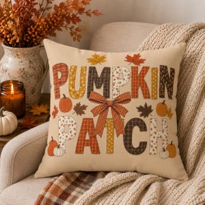Puede incluir: Un cojín cuadrado de fondo beige con el texto PUMPKIN PATCH en letras grandes rellenas de diversos patrones otoñales. Un lazo central de cuadros naranjas se sitúa entre las palabras, rodeado de pequeñas calabazas y hojas decorativas.