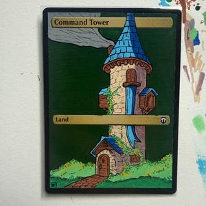 Puede incluir: Una carta coleccionable rectangular titulada Command Tower, que presenta una ilustración pintada a mano de una torre de piedra con techo azul, una puerta de madera y follaje verde sobre un fondo verde oscuro. La carta incluye el texto Command Tower y Land.