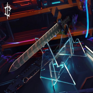 May include: A detailed image of a sword with a patterned blade, displayed on a clear acrylic stand. The sword has a dark handle and a blade with a camouflage-like design. The background is dark with neon lighting.