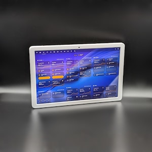 May include: A white-framed tablet shows a smart home control interface with a blue and purple colour scheme. The screen displays home automation data, including temperature, humidity, and light controls. The tablet is on a black surface.