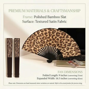 May include: A decorative hand fan with a leopard print design. The fan is made of polished bamboo and textured satin fabric. Folded length is 23cm, expanded width is 42cm. The image also shows two folded fans.