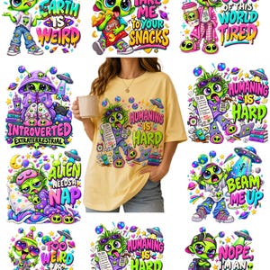 May include: A yellow t-shirt featuring a graphic of a green alien character with messy hair, wearing a purple hoodie and jeans, holding a to-do list and a coffee cup, with the text 'HUMANING IS HARD' surrounded by planets, stars, and a UFO.