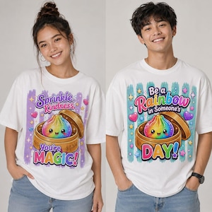 May include: Two white t-shirts featuring a colorful rainbow dumpling in a bamboo steamer. The left shirt displays the text "Sprinkle Kindness, You're MAGIC!" and the right shirt displays the text "Be a Rainbow in Someone's DAY!" with hearts and stars.