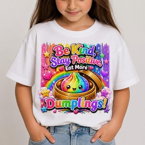 May include: A white short-sleeve t-shirt featuring a colorful graphic of a rainbow dumpling in a bamboo steamer. The text reads Be Kind, Stay Positive, Eat More Dumplings! surrounded by rainbow colors, stars, and hearts on a vibrant background.