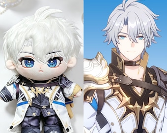 May include: A plush doll featuring a character with short white hair and bright blue eyes, wearing a detailed white, black, and gold outfit with star-shaped accents, displayed alongside a matching digital illustration of the same character.