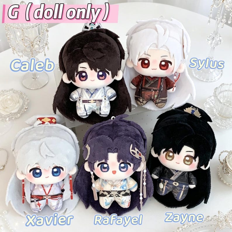 Puede incluir: Cinco mu&ntilde;ecos de peluche etiquetados como Caleb, Sylus, Xavier, Rafayel y Zayne. Cada mu&ntilde;eco presenta colores de pelo distintos, incluyendo negro, blanco y morado, y viste trajes detallados. Tienen grandes ojos bordados y cuerpos suaves.