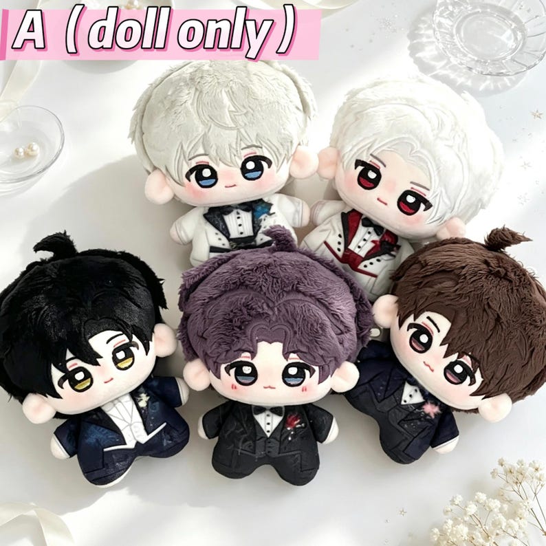 Puede incluir: Cinco mu&ntilde;ecos de peluche con rasgos faciales y cabello bordados, cada uno con un traje de esmoquin formal. Los mu&ntilde;ecos tienen colores de cabello variados que incluyen blanco, negro, morado oscuro y marr&oacute;n, con trajes detallados y pajaritas.