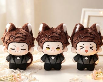 May include: Three plush dolls featuring brown hair, pointed animal ears with white inner details, and dark grey suits with black trousers. Each doll has a distinct facial expression: one with closed eyes, one with yellow eyes, and one with a wide smile.