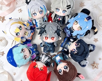 May include: A selection of anime-style plush dolls. The dolls have different hair colours, outfits, and facial expressions. They are displayed on a white surface with star-shaped decorations.