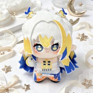 May include: A plush doll with white hair and yellow and blue accents. The doll has large blue eyes and is wearing a white and blue outfit. The doll is a cute, anime-style character.