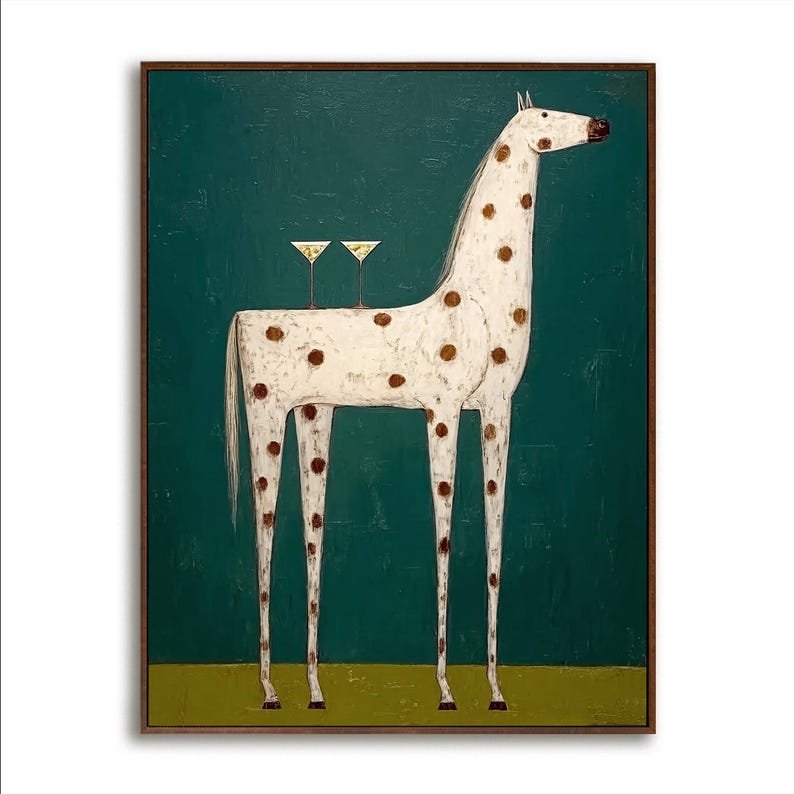 May include: A whimsical painting of a white horse with brown spots, standing against a teal background. Two martini glasses sit on the horse's back. The artwork is framed in a dark wood.