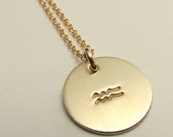 Collar con símbolo del zodíaco relleno de oro y colgante con dije estampado.