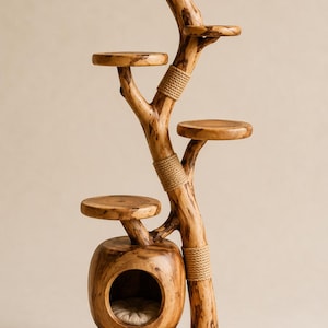 Peut inclure: Arbre à chat en bois artisanal avec plusieurs plateformes et une cachette confortable. La finition en bois naturel et le design en forme d'arbre créent une pièce élégante et fonctionnelle pour l'enrichissement félin. L'arbre à chat mesure environ 152 cm de haut.