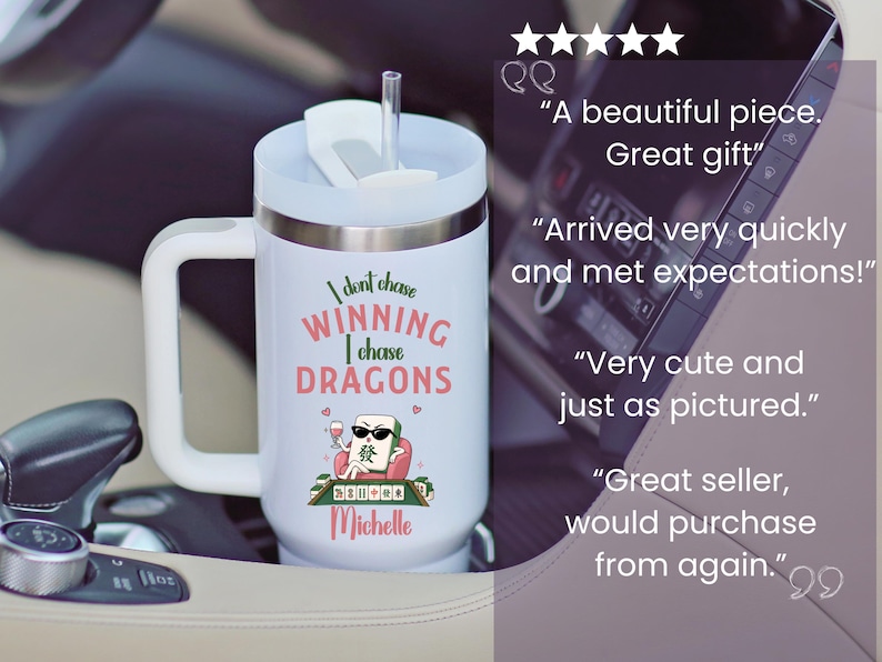 May include: A white insulated tumbler with a handle and a clear straw. The front features a graphic of a mahjong tile character wearing sunglasses, holding a wine glass, with the text: I dont chase WINNING I chase DRAGONS and the name Michelle.