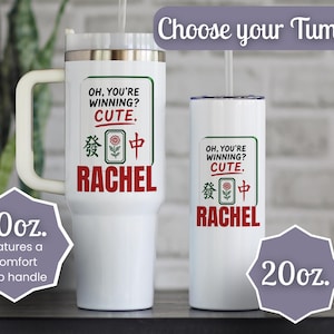 May include: Two white stainless steel tumblers, one 40oz with a handle and one 20oz, both featuring the text 'OH, YOU'RE WINNING? CUTE.' above a Mahjong tile graphic and the name 'RACHEL' in red. Each includes a clear lid and a straw.