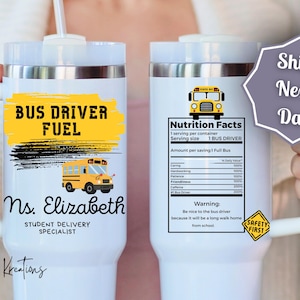 May include: White travel mug with a handle and a straw. The mug features a yellow and black design with the text "BUS DRIVER FUEL" and a school bus illustration. It also includes the name "Ns. Elizabeth" and "STUDENT DELIVERY SPECIALIST".