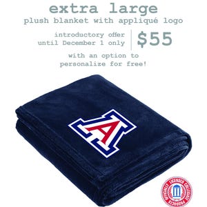 May include: An extra large navy blue plush blanket featuring an appliquéd red and white letter A logo. The text reads: extra large plush blanket with appliqué logo, introductory offer until December 1 only, $55, with an option to personalize for free!