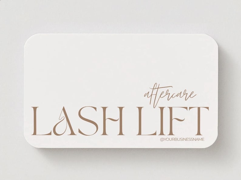 May include: A rectangular business card with rounded corners. The card is off-white with the words "LASH LIFT" in a brown serif font. Above the words is the word "aftercare" in a script font. The text "@YOURBUSINESSNAME" is at the bottom.
