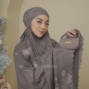 May include: A taupe prayer garment featuring a matching head covering and a small rectangular handbag. The fabric displays a repeating geometric pattern with floral accents and scalloped edges. The handbag includes a gold-tone label reading Jumuna.