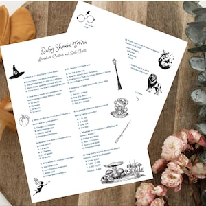 Puede incluir: Dos hojas de papel blanco con texto e ilustraciones en negro para un juego de trivia para baby shower. El juego incluye preguntas sobre literatura y datos sobre bebés. Un mordedor y un chupete de madera están en primer plano.