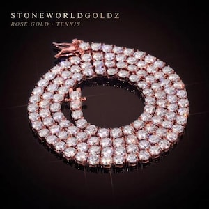 May include: Rose gold tennis necklace with sparkling clear stones. The necklace is displayed on a dark reflective surface. The text "STONEWORLDGOLDZ" and "ROSE GOLD - TENNIS" is visible in the image.