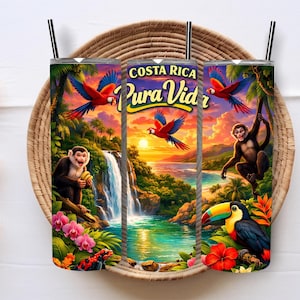 May include: Three stainless steel tumblers with a tropical Costa Rica design. The design features parrots, monkeys, a toucan, and the text "Costa Rica Pura Vida" against a sunset backdrop. Each tumbler has a black straw.
