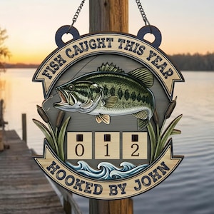 May include: Wooden fishing sign with the text "FISH CAUGHT THIS YEAR" and "HOOKED BY JOHN". The sign features a detailed illustration of a largemouth bass, cattails, and a counter showing "012".