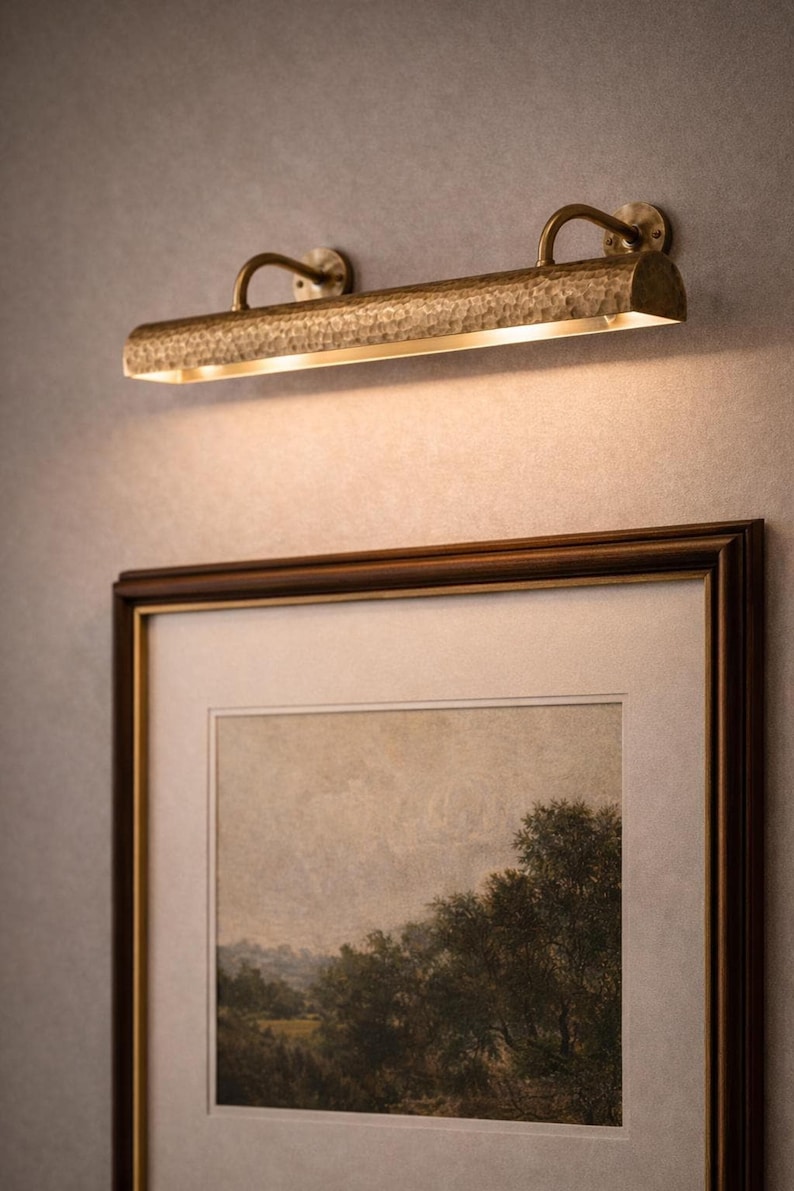solid brass picture light above framed landscape, hand-hammered bar, warm antique brass glow