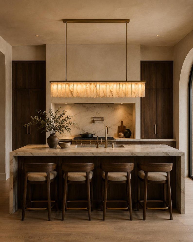 Alabaster linear chandelier over kitchen island, warm glowing stone fins, brushed brass rods