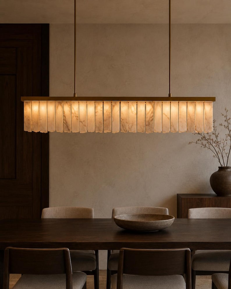 Contemporary stone pendant light hanging over small table, alabaster linear chandelier with warm tone