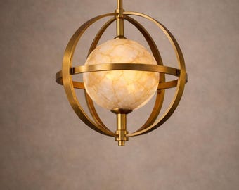 Könnte beinhalten: Eine Pendelleuchte in Messingoptik mit einem kugelförmigen, marmorierten Glasschirm. Der Schirm ist von konzentrischen Ringen umgeben, die an einer zentralen Stange aufgehängt sind. Die Leuchte ist für die Deckenmontage konzipiert und strahlt ein warmes Licht aus.