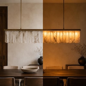 Modern alabaster chandelier above dining table, slim brass canopy, soft amber light and veining