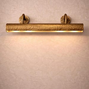 solid brass picture light, front view close to wall, antique brass finish, focused museum art light