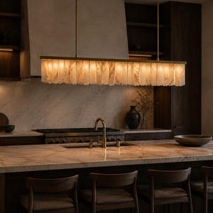 Alabaster kitchen island light, soft ambient glow above bar stools, minimalist brass linear chandelier