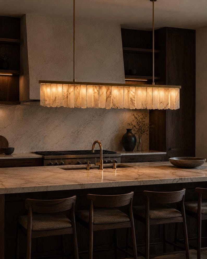 Alabaster kitchen island light, soft ambient glow above bar stools, minimalist brass linear chandelier