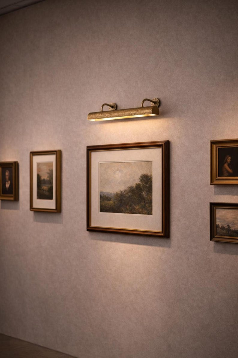 Room view with solid brass picture light over central artwork, wall mounted picture light, refined gallery look