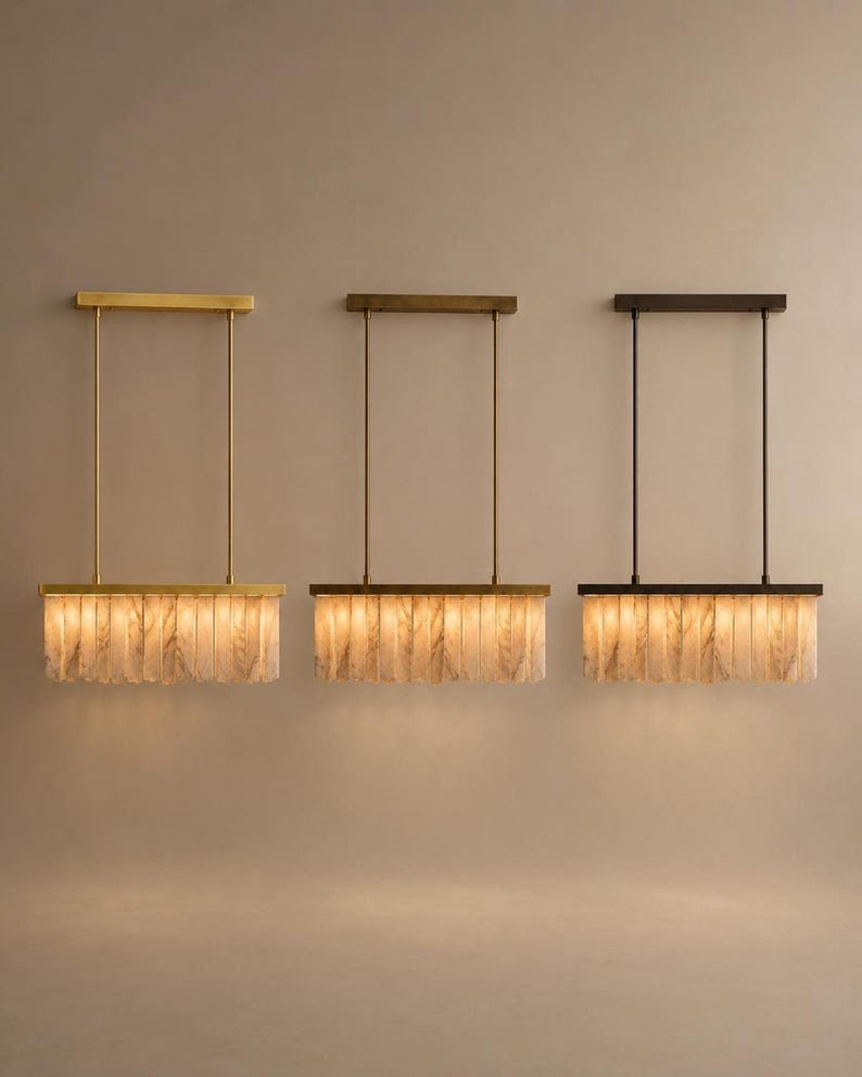 Three brass linear chandeliers mounted at staggered drops, alabaster fins glowing softly