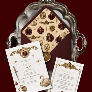 K&ouml;nnte beinhalten: Elegante Hochzeitseinladung mit burgunderfarbenem Umschlag und goldenen Verzierungen. Das Design umfasst Granat&auml;pfel, Schw&auml;ne und die Namen "Emily und Joshua". Die Einladungskarten enthalten das Datum: Samstag, 21. September 2026.