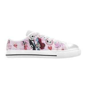 Puede incluir: Zapatillas de lona blancas con un dise&ntilde;o rosa y blanco con personajes de "Pesadilla antes de Navidad". El dise&ntilde;o incluye a Jack Skellington, Sally y otros gr&aacute;ficos tem&aacute;ticos. Los zapatos tienen cordones blancos y una franja negra en la suela.