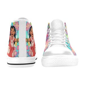 Puede incluir: Zapatillas altas blancas con un dise&ntilde;o floral y de personajes colorido. El dise&ntilde;o incluye un personaje de dibujos animados con un vestido rojo y un collar de flores. Las zapatillas tienen cordones y suelas blancas.