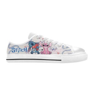 Pu&ograve; includere: Scarpe da ginnastica in tela bianca con una grafica colorata dei personaggi Stitch e Angel. Le scarpe hanno una suola in gomma bianca con una striscia nera e lacci bianchi. La parola "Stitch" &egrave; stampata sul lato.