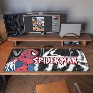 May include: A rectangular Spider-Man mousepad featuring the superhero in red and blue, with the words "SPIDER-MAN" in white and red. The background is black and white.