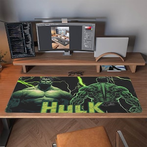 Könnte beinhalten: Schwarze Schreibtischunterlage mit dem Hulk. Die Matte hat ein grünes und schwarzes Design mit dem Wort "HULK" in grünen Blockbuchstaben. Der Hulk wird in zwei Posen dargestellt, mit Blitzen im Hintergrund.
