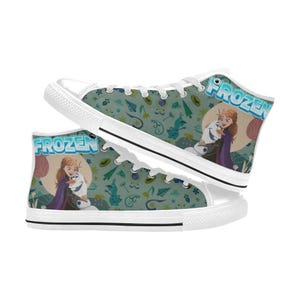 Może przedstawiać: Wysokie trampki z pł&oacute;tna z motywem Frozen. Buty mają białą gumową podeszwę i sznurowadła. Boki przedstawiają Annę i Olafa obejmujących się, ze słowem "FROZEN" w kolorze niebieskim. Tło to wz&oacute;r w kolorze morskim ze śnieżynkami.